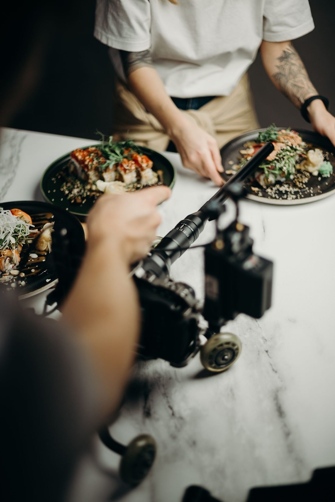 A camera filming plated dishes during a content production shoot